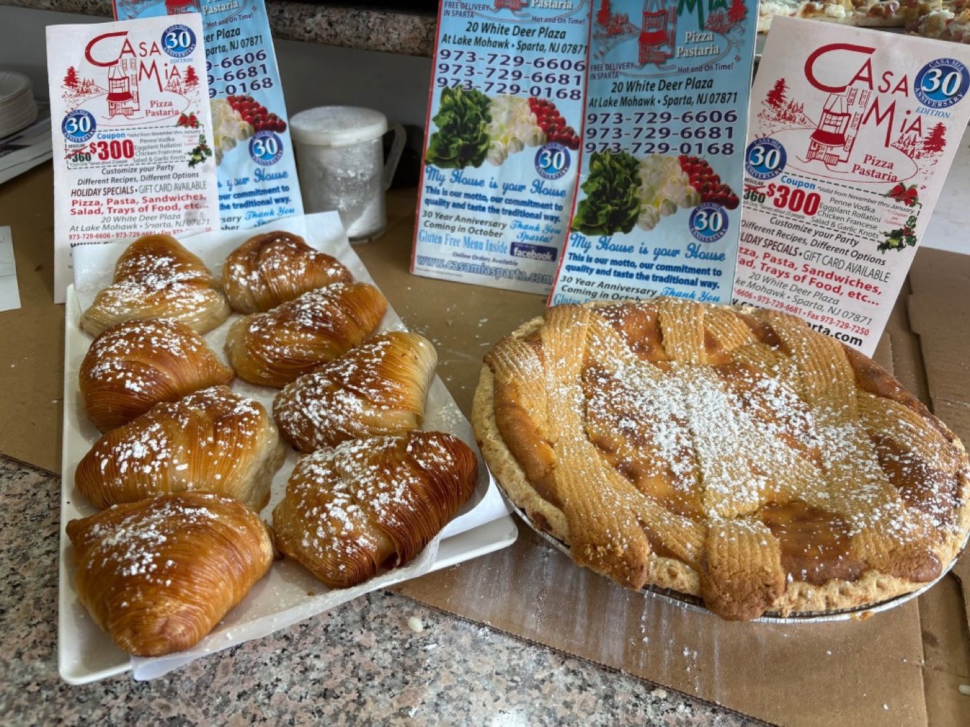 Sfogliatelle and a powdered lattice pastry beside Casa Mia menus.